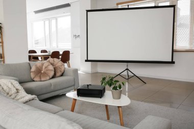 Boş projektör ekranlı ve kanepeli ışık odasının içi