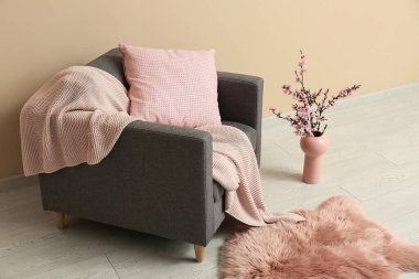 Gri koltuklu ve çiçek açan ağaç dalları olan şık bir oturma odası.