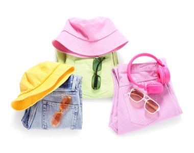 Beyaz arka planda izole edilmiş aksesuar ve kulaklıklı şık kadın bahar kıyafetleri.