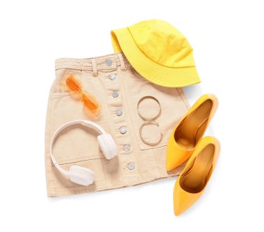 Beyaz arka planda aksesuarları ve kulaklıkları olan şık bir kadın bahar kıyafeti.