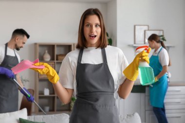 Odada paçavra ve deterjanı olan genç bir kadın hademe.