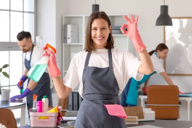 Deterjanı olan genç bayan hademe ofiste iyi görünüyor.