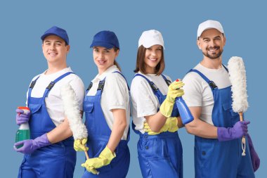 Mavi arka planda temizlik malzemeleri olan bir grup genç hademe.