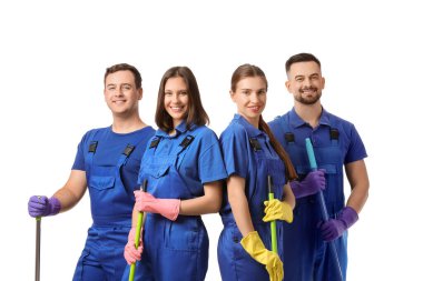 Beyaz arka planda paspasları ve süpürgesi olan genç hademeler.