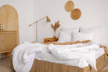 Yatak, masa ve lamba üzerinde yumuşak çarşaflar olan rahat bir odanın içinde.