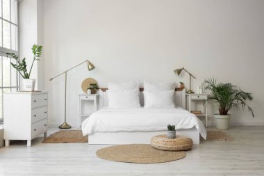 Beyaz çarşaflı, masalı ve lambalı aydınlatma odasının içinde.