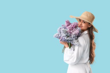 Beautiful young woman with bouquet of blooming lilac flowers on blue background