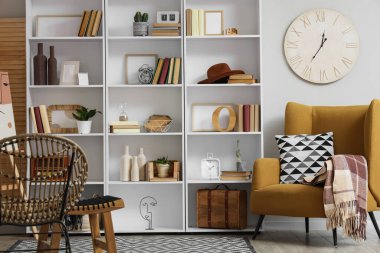 Kitaplığı ve koltuğu olan oturma odasının içinde.