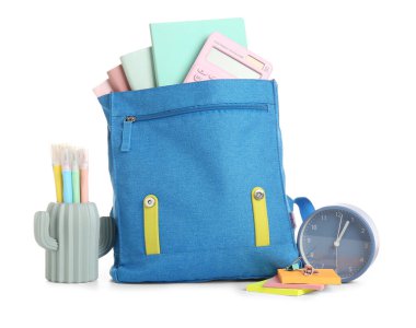 Alarm saati ve okul çantası beyaz arkaplanda izole edilmiş kırtasiye malzemesi