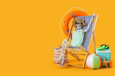 Güverte sandalyesinde insan iskeleti ve sarı arka planda plaj aksesuarları.