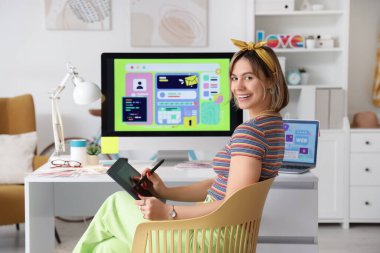 Ofisteki masada grafik tabletle çalışan güzel bir web tasarımcısı