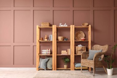 Odanın içinde ahşap raf ünitesi ve koltuk var.