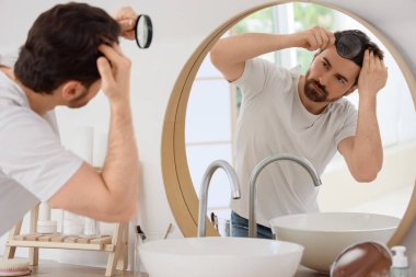 Adam aynaya bakmak saç dökülmesi sorunu ile