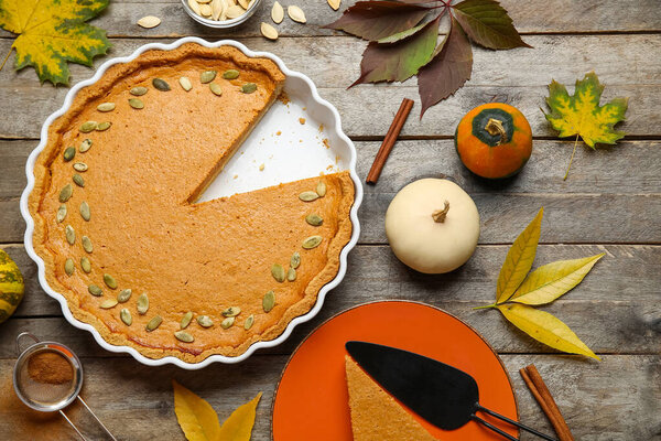 Осенняя композиция с вкусным тыквенным пирогом на деревянном фоне