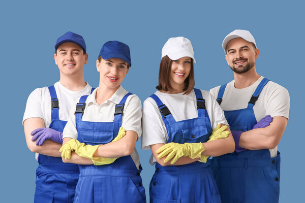 Команда молодых уборщиков на синем фоне