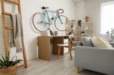 İş yeri, bisiklet ve raf ünitesi olan ev içi ofis.