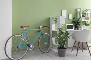 İş yeri, bisiklet ve raf ünitesi olan ev içi ofis.