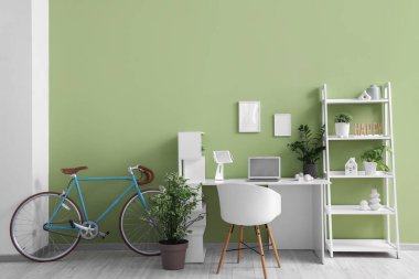 İş yeri, bisiklet ve raf ünitesi olan ev içi ofis.