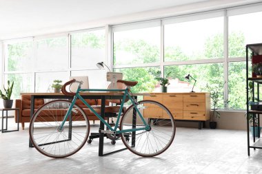 Ev içi ofis masasının yanında modern bisiklet