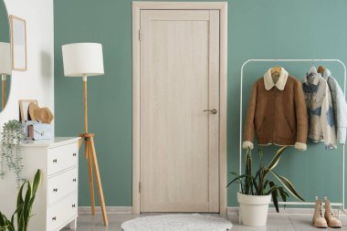 Şık koridorun içinde kapısı, lambası ve askısı var.