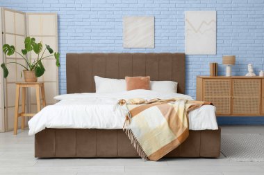 Katlanmış ekran ve palmiye bitkisi olan yatak odasının içi