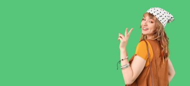 Dişi hippi yeşil arka planda zafer jesti ve metin için yer gösteriyor