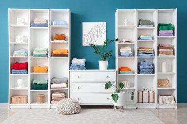 Çekmeceleri ve şık kadın kıyafetleriyle dolu bir dolap.