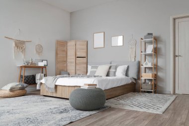 Şık yatak odasının içinde raf ünitesi, masa ve puf