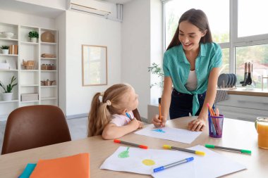 Mutfakta çizim yapan küçük tatlı bir kızı olan dadı.