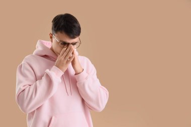 Bej arka plandaki endişeli genç adam