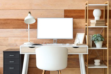 Odasında ahşap duvarın yanında modern bilgisayarlı rahat bir iş yeri.