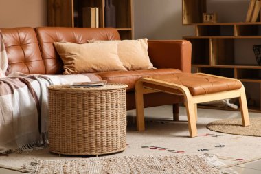 Hasır sepetli, rahat kanepeli ve ayaklı oturma odasının içinde.