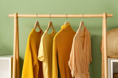 Yeşil duvarın yanında sarı elbiselerle dizilin.