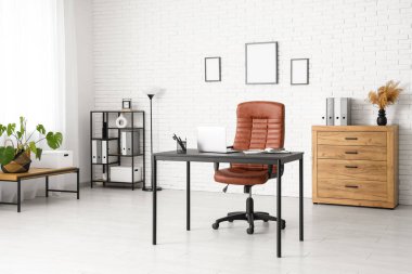 Çalışma yeri, lamba ve raf ünitesi olan modern ofis.