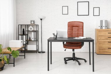 Çalışma yeri, lamba ve raf ünitesi olan modern ofis.