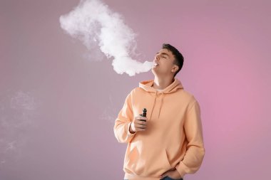 Genç adam arka planda elektronik sigara içiyor.