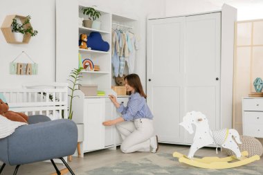 Kreşteki çekmeceyi açan genç kadın.