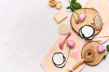 Pamuk pedler, banyo malzemeleri ve açık arkaplanda çiçekler.