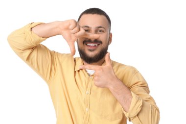 Genç adam beyaz arka planda gülümsemesini gösteriyor.