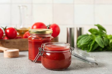 Gri masada lezzetli ketçap ve fesleğen yaprakları.