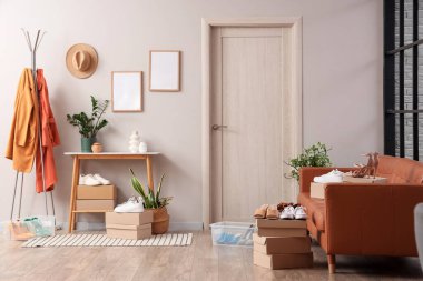 Koridorun içinde kadın ayakkabıları, askılık ve kanepe var.