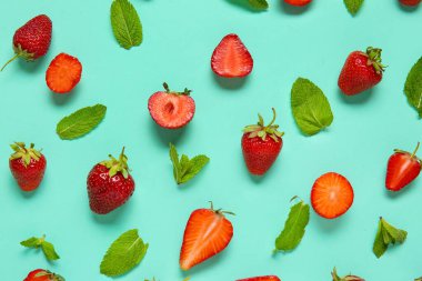 Turkuaz arka planda taze taze çilek ve nane yaprağı.