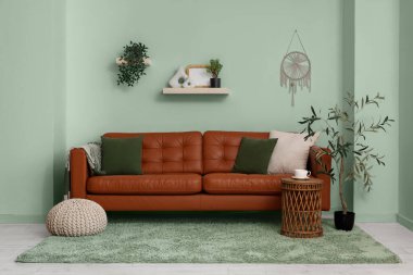 Kahverengi deri kanepe ve yumuşak puf ile modern oturma odası.