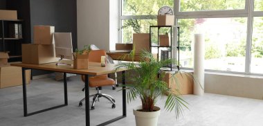 Taşındığı gün bilgisayar monitörü ve karton kutuları olan modern işyeri