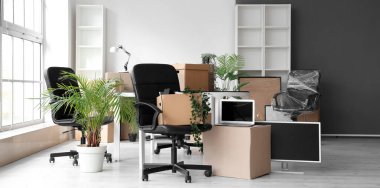 Taşınma gününde sandalyeleri, çiçekleri ve karton kutuları olan modern ofis.
