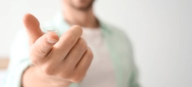 Yatak odasında lensli genç adam, yakın plan.