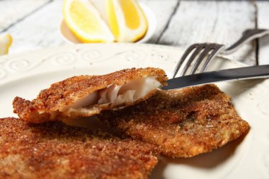 Hafif ahşap arka planda kızarmış morina balığı tabağı, yakın plan.