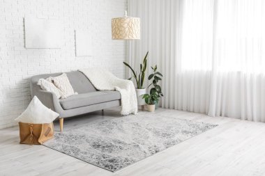 Pencerenin yanında rahat kanepesi olan şık bir oturma odası.