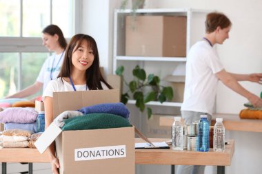 Merkezdeki fakir insanlar için bağış yapan genç bir kadın gönüllü.