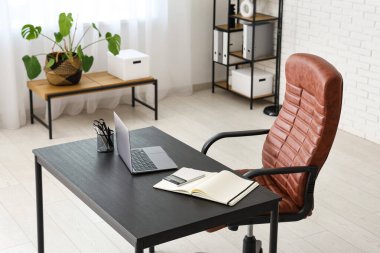 Dizüstü bilgisayarı ve koltuğu olan bir iş yeri